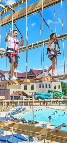 Father and kids are walking across the high ropes course