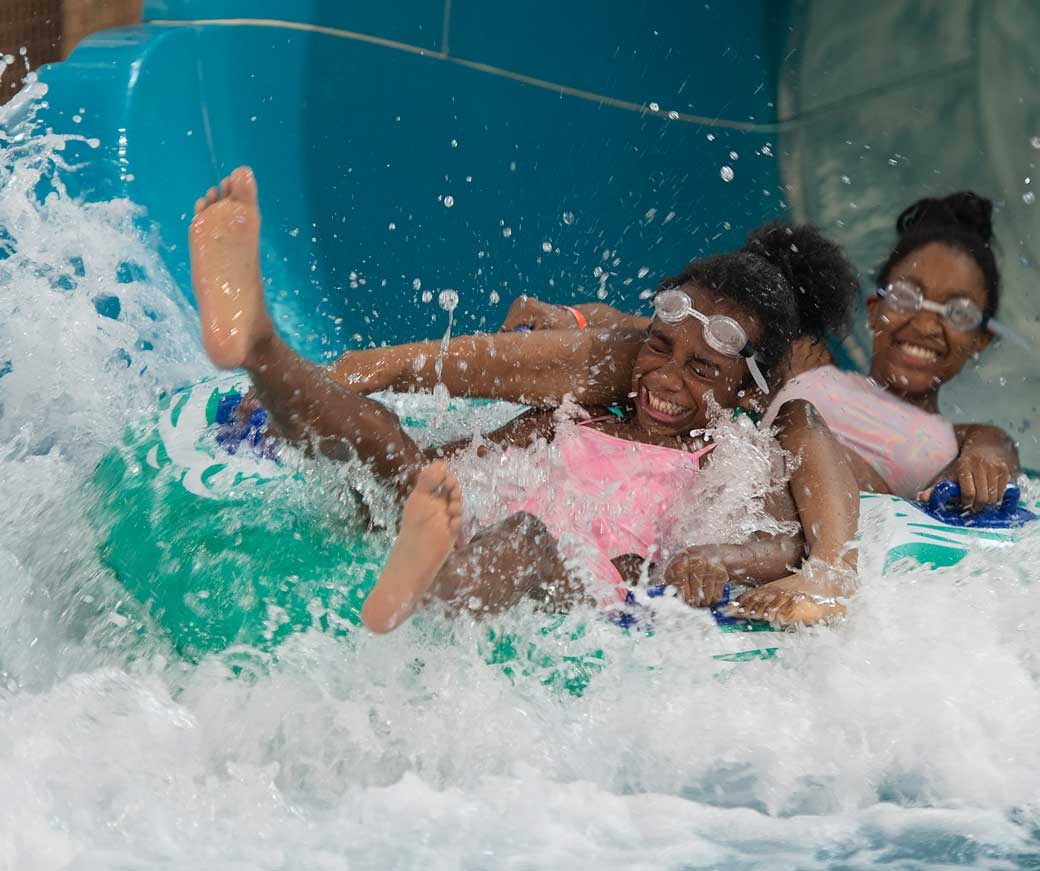 Two girls ride down Rapid Racer water slide