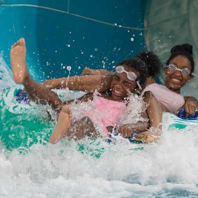 Two girls ride down Rapid Racer water slide