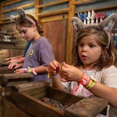 A boy and girl sifting through stones at Oliver's Mine