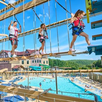 Father and kids are walking across the high ropes course