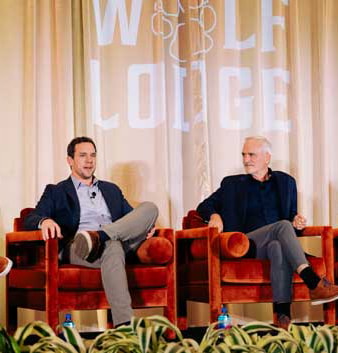 Two pack members on stage speaking